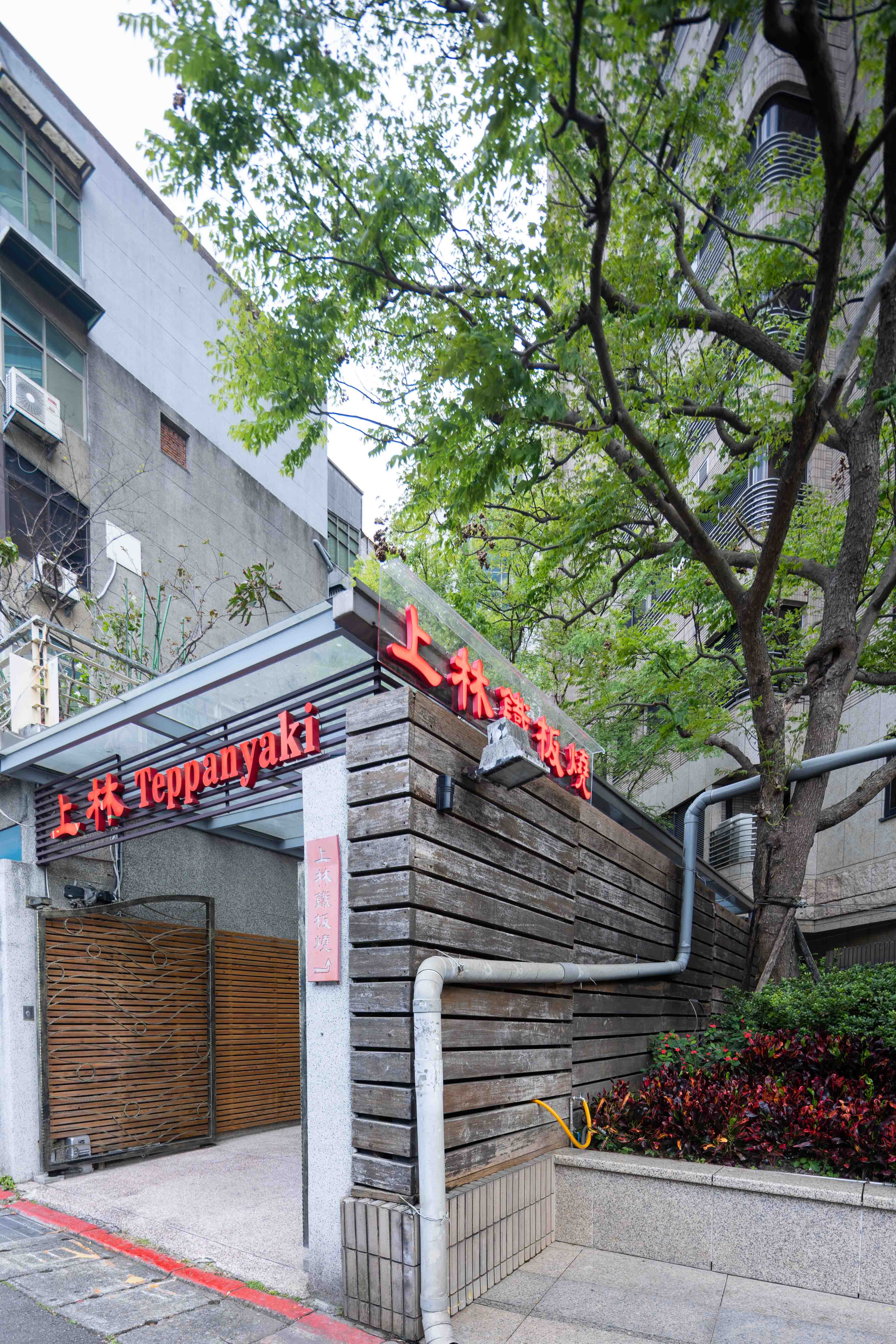 台北市鐵板燒料理餐廳開放式廚台，廚師正在鐵板上烹飪海鮮和肉類